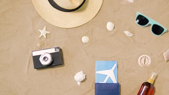 Travel Tickets, Camera and Hat on Beach Sand