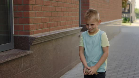 School Boy is Holding the Paper and Puts It to the Correct Bin for Paper