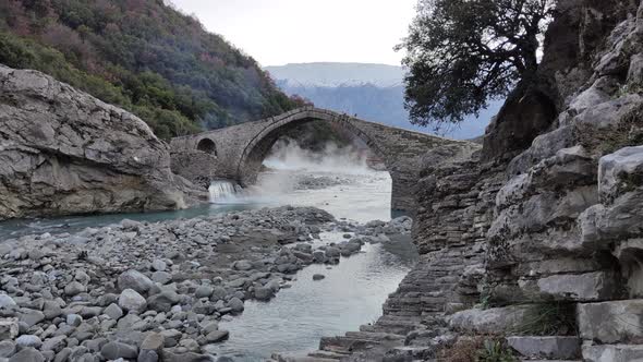 Stone bridge during sunset. Steam coming out of thermal baths