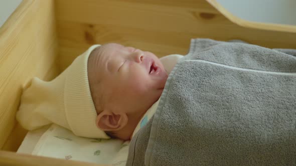 Baby face lying in bed and yawning.