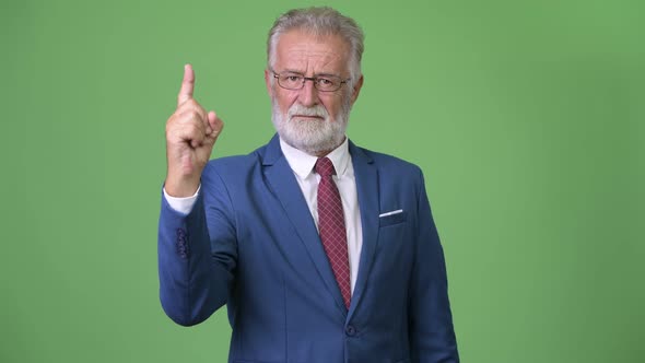 Handsome Senior Bearded Businessman Against Green Background