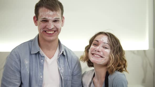 Portrait of Cute Positive Couple with Smudged with Flour Face Standing in the Kitchen