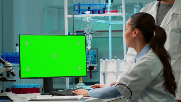 Man Talking with Lab Technician and Working with Green Mockup Pc