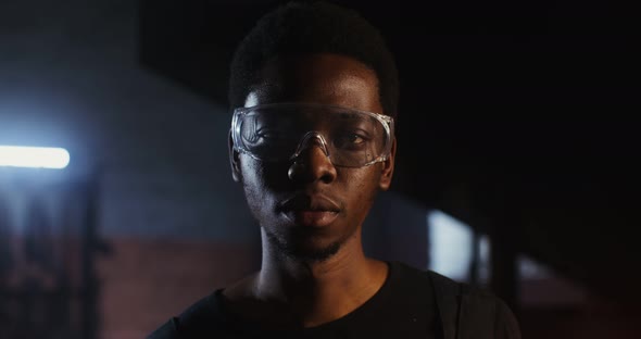 A Young Blacksmith of African American Appearance in Goggles Looks at the Camera