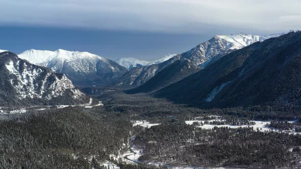 Air Flight Through Mountain Clouds Over Beautiful Snowcapped Peaks of Mountains and Glaciers