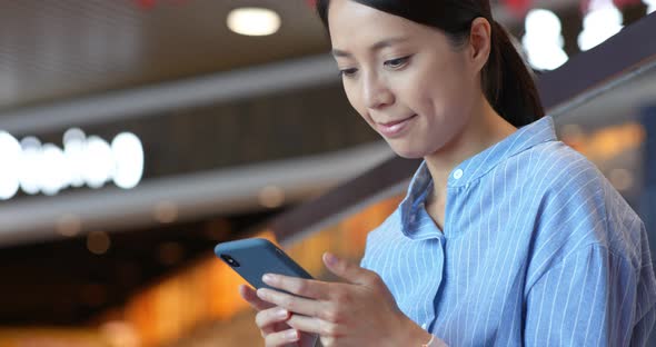 Woman use of mobile phone inside shopping center