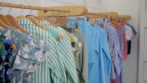 Wooden Hangers with Fashionable Colorful Clothes on Rack