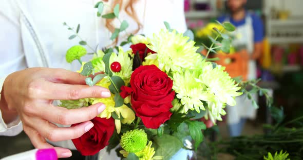 Female florist arraigning flower in flower vase