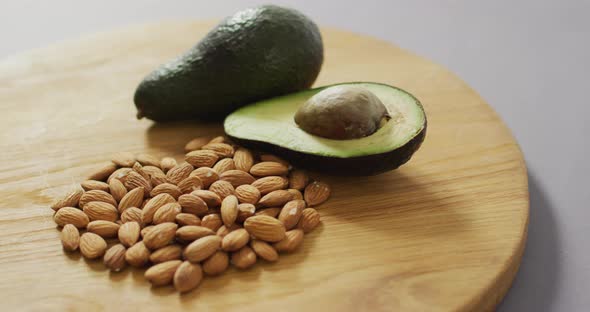 Video of almonds and avocado on wooden background
