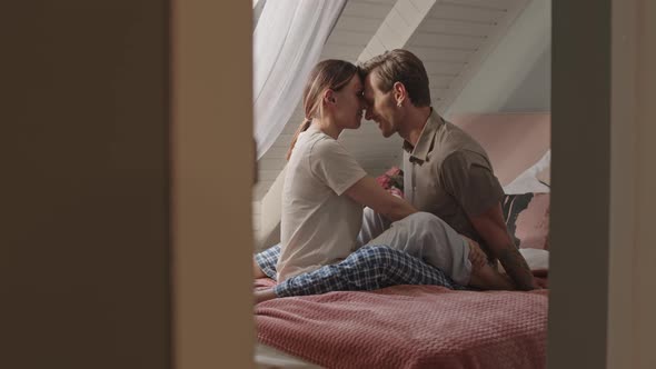 Passionate Couple Sitting on Bed