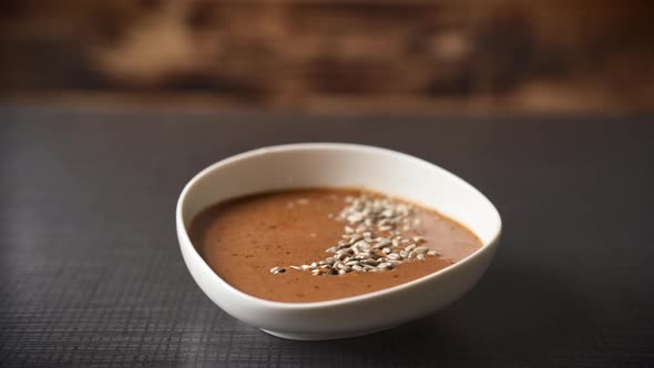 Chefs Hand Serving the Soup with Some Fresh Greens