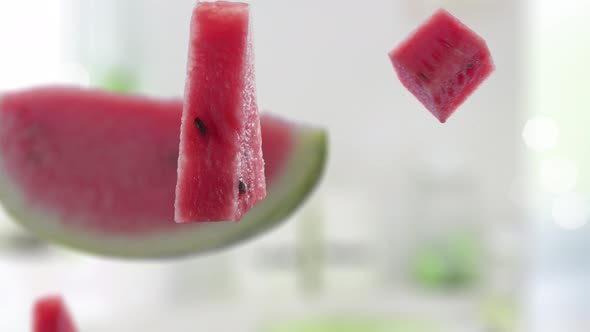 Flying of Watermelon and Slices in White Kitchen Background