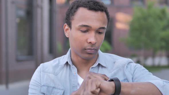 African Man Using Smartwatch Outdoor