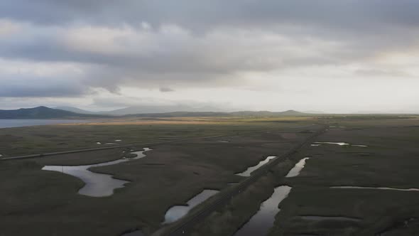 Drone View of a Sunset in a Valley with a River and Mountain Ranges