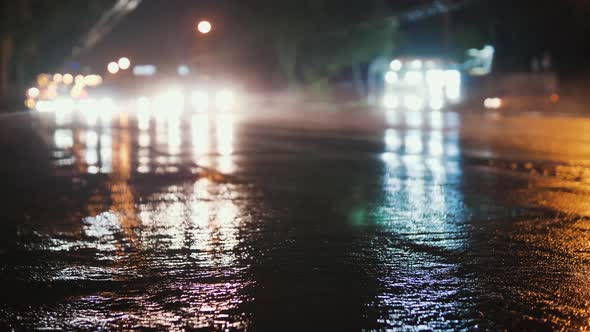 Defocus on the City Road. A Static Frame of the Road After the Rain. Cars Pass and the Headlights