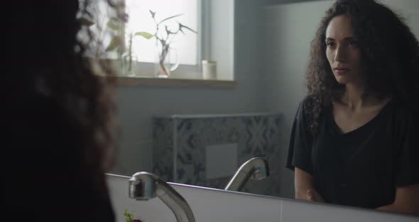 Woman looking at herself through mirror