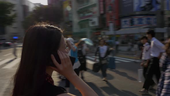 Japanese Woman Talks On Smartphone In Shibuya Crossing In Tokyo