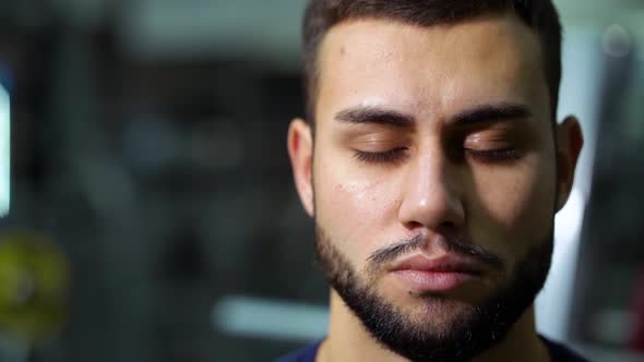 Bearded Man Opening Eyes in Gym