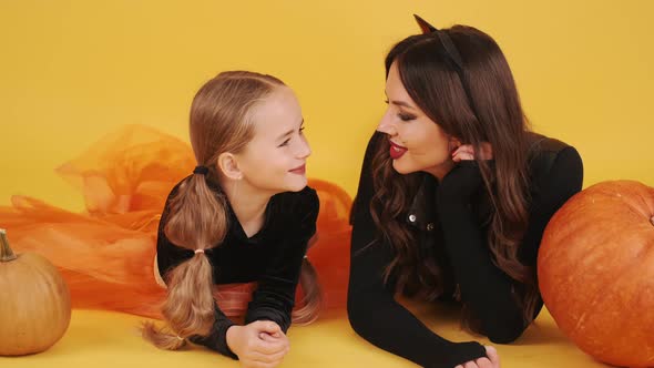 Mother and Daughter with Wearing Halloween Costumes Have in Orange Studio