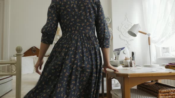 Woman taking a seat in her workroom