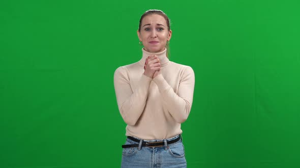 Hopeful Slim Woman Holding Hands Together Praying at Chromakey Background