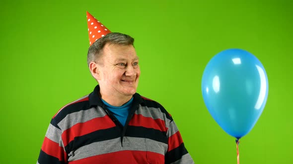 Emotional Mature Adult Man of Caucasian Ethnicity in Casual Clothes and Birthday Cap