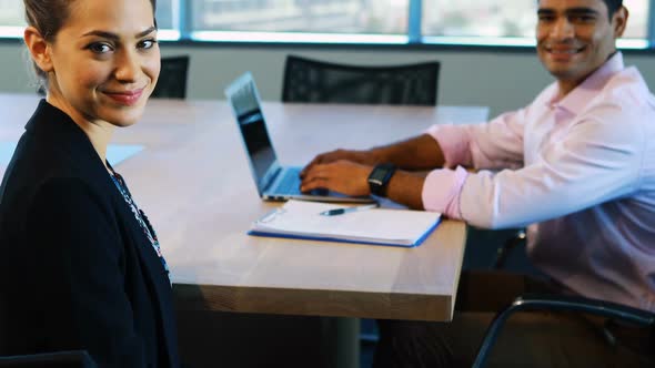 Businesswoman and colleague sitting together in office