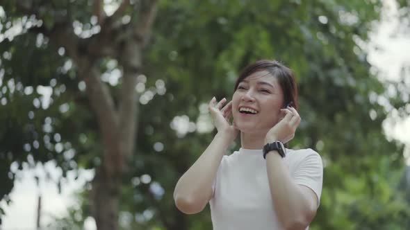 slow-motion of woman walking and listening to music with wireless headphones