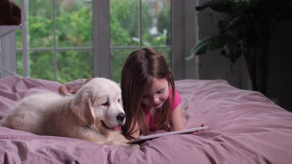 Joyful Child Watching Youtube on Tablet with Puppy