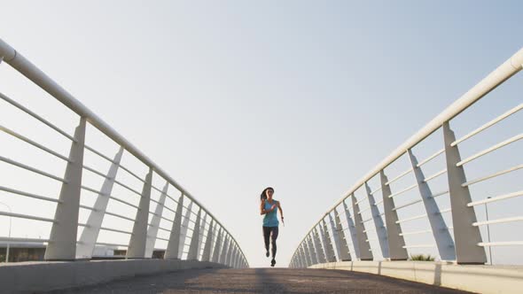 Young woman running on a bridge