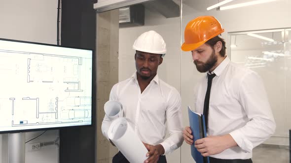 Architect and Engineer Looking at Scketch Blueprint at Office and Discussing Project