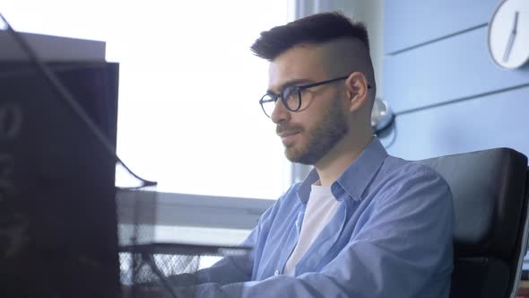 a young European male businessman works at a laptop computer in the office at home