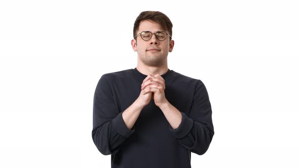 Concentrated Man in Black Sweatshirt and Glasses Wishing Holding Hands Together for Pray with Closed