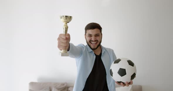 A Young Indian Football Fan is Watching TV at Home