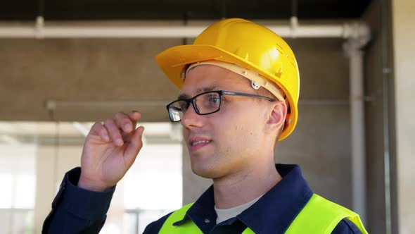 Male Builder in Helmet and Safety West at Office