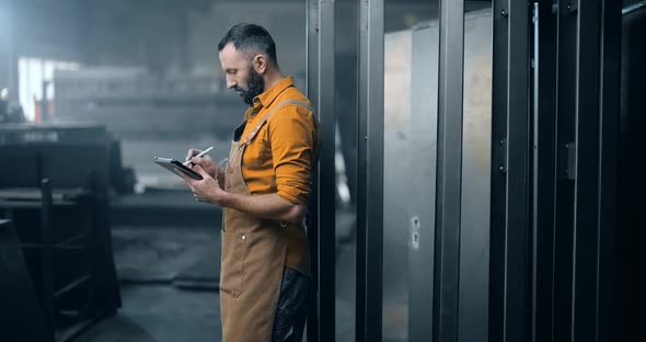 Worker Checking the Quality of Metal Products with a Digital Tablet