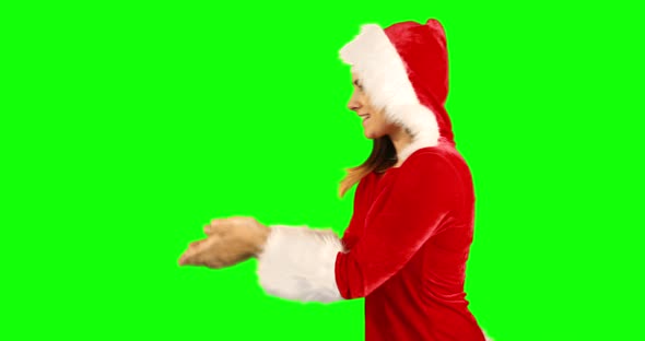 Girl in santa hat blowing over hands and looking at camera 4k