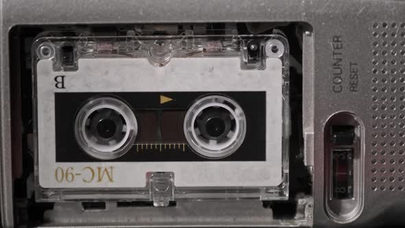 Vintage Audio Tape with a Blank Label Spinning in Cassette Recorder Closeup