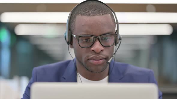 Portrait of African Businessman with Headset Working on Laptop