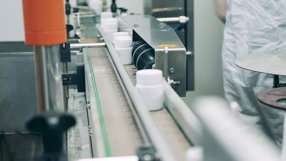 Line of Pill Jars Moving Along the Conveyor Belt