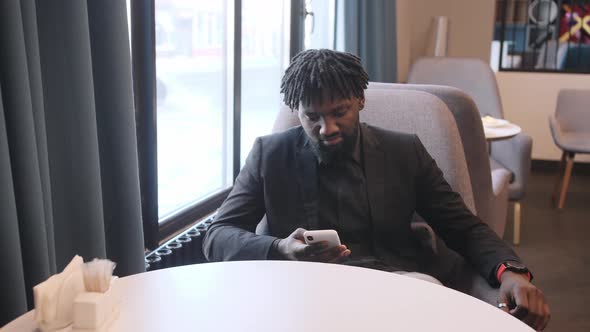 Young Afro American Business Man Having Breakfast in the Hotel Restaurant