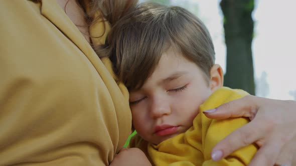 Child napping in the mother's arms