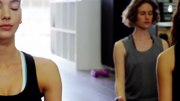 Women practicing yoga in fitness studio
