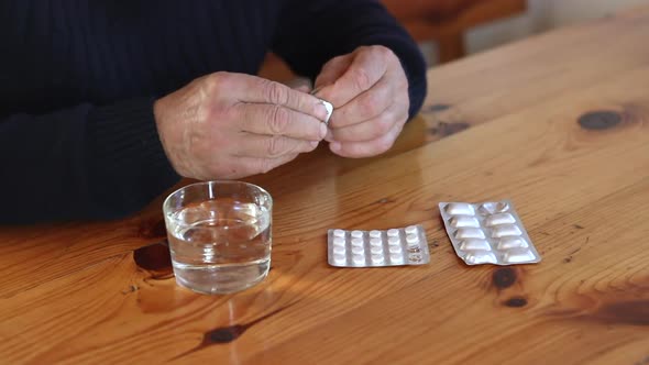 Senior Man Drink Pill with Water From Glass