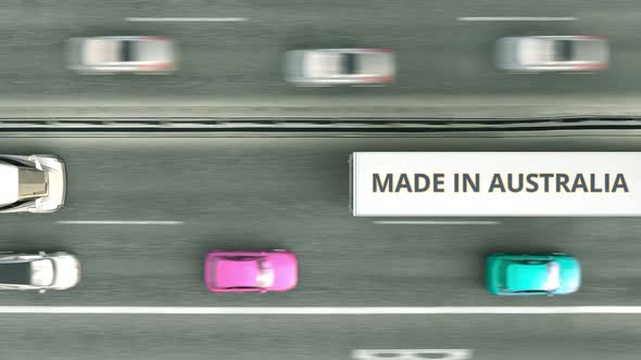 Trucks with MADE IN AUSTRALIA Text Driving Along the Highway alt