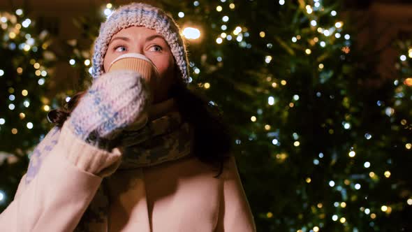 Happy Woman Drinking Coffee Over Christmas Lights