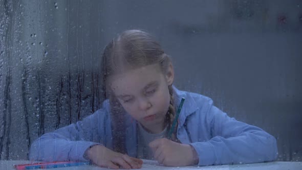 Nice Little Girl Painting Behind Rainy Window, Orphan Child Dreaming About Home