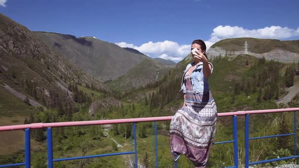 A Girl Making Selfie on a Background of Mountains and Forests