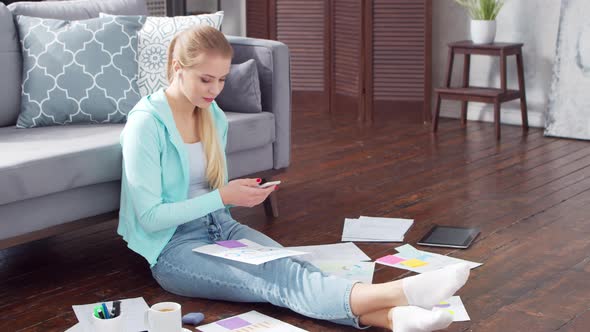 Young woman works with documents using a laptop at home.