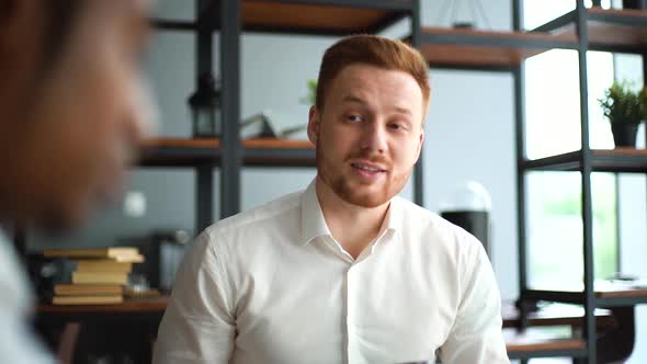 Close-up Face of Young Businessman Talking To African American Business Partner About New Project.